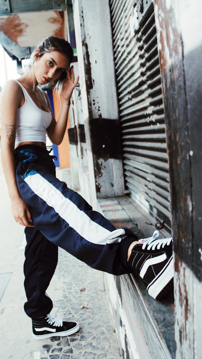 Trendy woman in casual urban streetwear poses outdoors, showcasing modern street style.